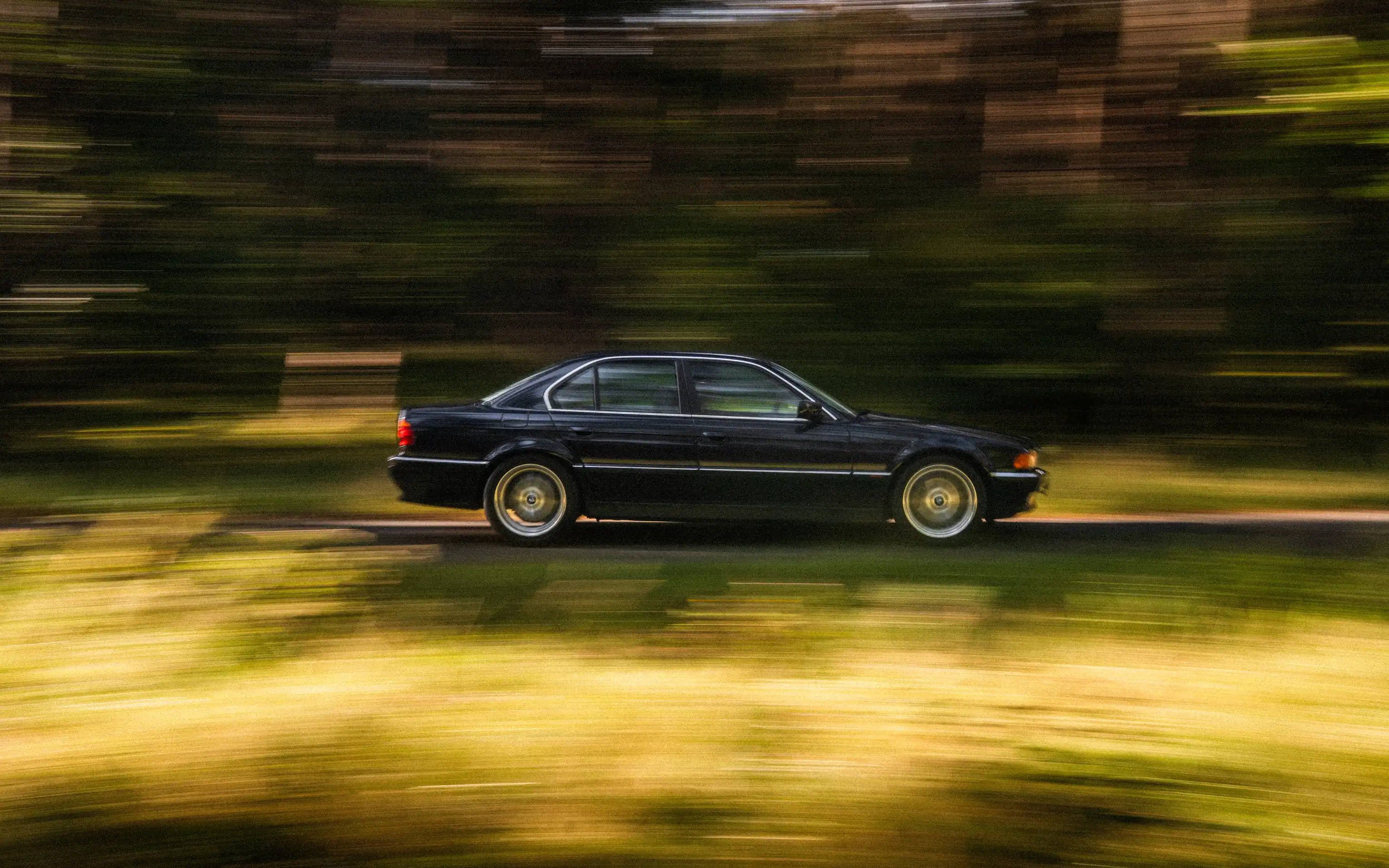 BMW E38 travelling on a forest road
